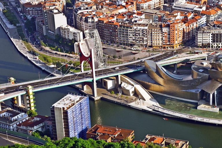 The Nervión river at Abandoibarra in Bilbao, the promenade and the Guggenheim along the far bank.