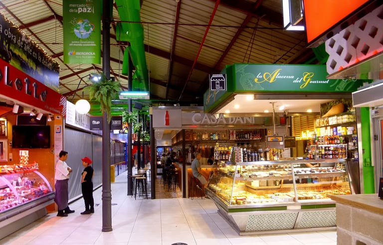 Deli and gourmet counters inside the Mercado de la Paz food market in Madrid's Salamanca district.